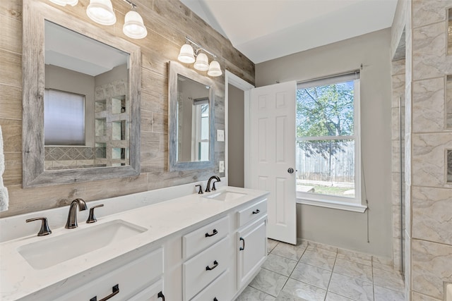 bathroom featuring vanity, lofted ceiling, and tile walls