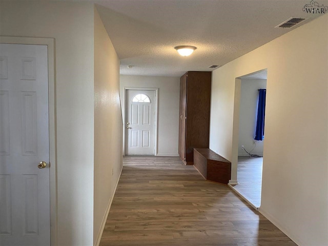 hallway featuring hardwood / wood-style floors and a textured ceiling