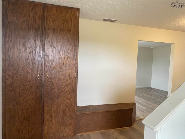 empty room with hardwood / wood-style floors and a textured ceiling