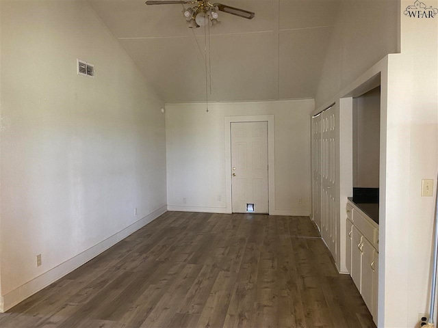 interior space featuring dark wood-type flooring, ceiling fan, and high vaulted ceiling