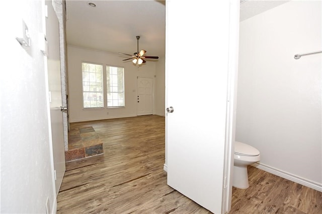 bathroom with wood-type flooring, ceiling fan, and toilet