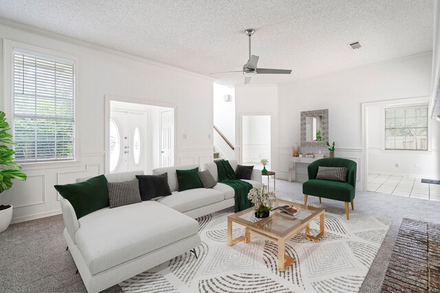 carpeted living room featuring ceiling fan, crown molding, a healthy amount of sunlight, and a textured ceiling