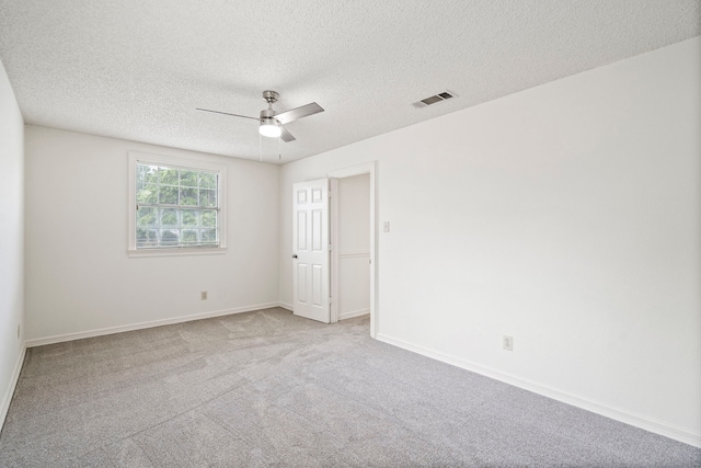 carpeted empty room featuring ceiling fan and a textured ceiling