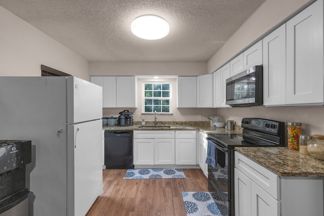 kitchen featuring dark hardwood / wood-style flooring, white cabinets, black appliances, sink, and a textured ceiling