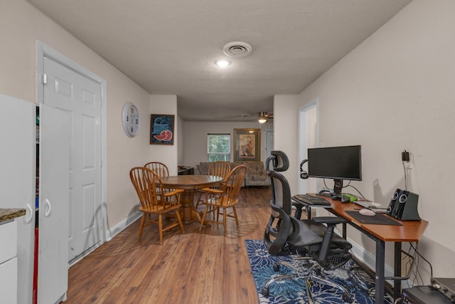 dining space with a textured ceiling, hardwood / wood-style flooring, and ceiling fan