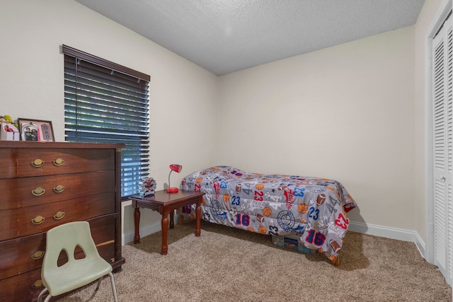 carpeted bedroom with a textured ceiling and a closet