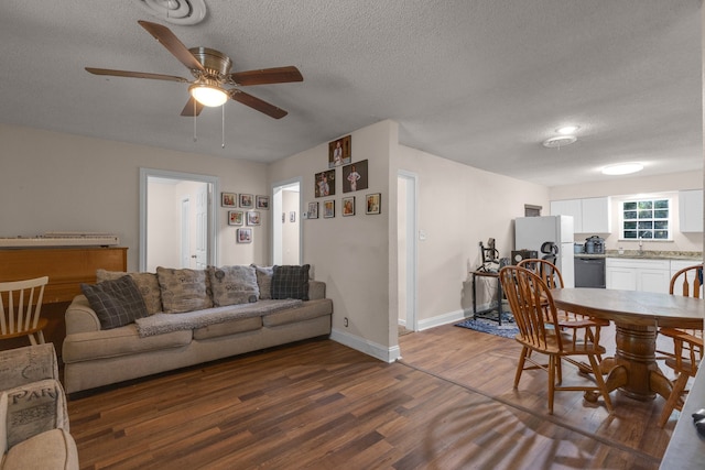 living room with dark hardwood / wood-style flooring, a textured ceiling, ceiling fan, and sink