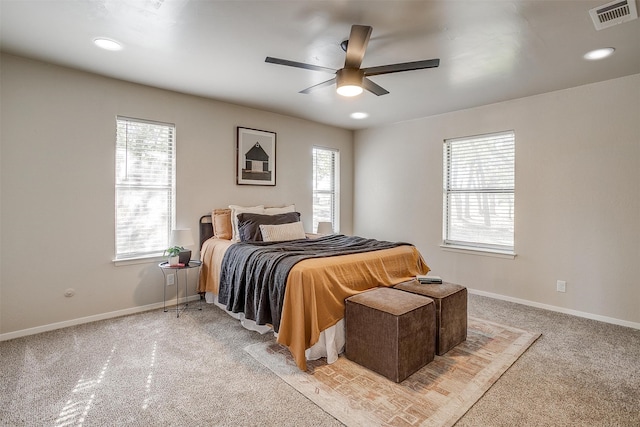 carpeted bedroom with ceiling fan and multiple windows