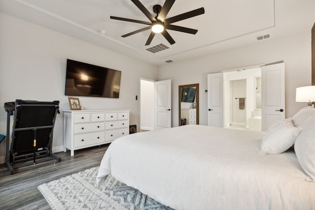 bedroom with dark hardwood / wood-style flooring, ensuite bath, and ceiling fan