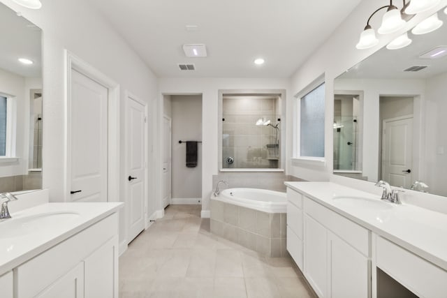 bathroom with plus walk in shower, vanity, and tile patterned flooring