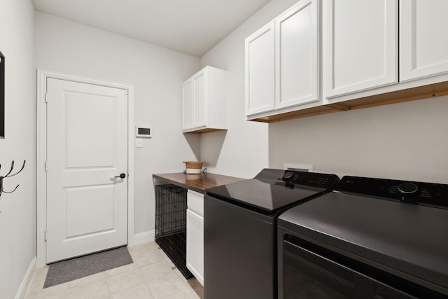 clothes washing area featuring washer and clothes dryer and cabinets