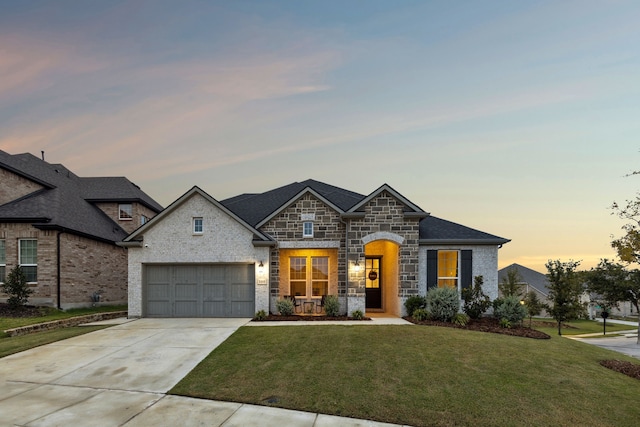 french provincial home with a yard and a garage