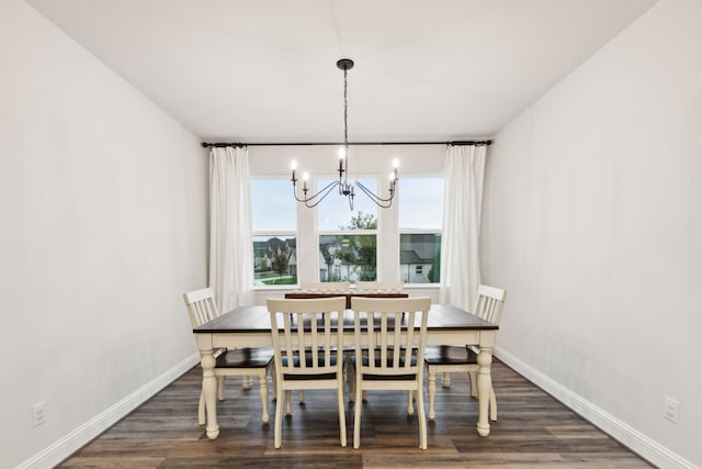 dining room with dark hardwood / wood-style floors and an inviting chandelier