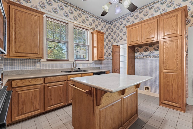 kitchen with a kitchen bar, a center island, light tile patterned floors, sink, and ceiling fan