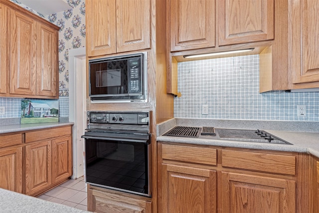 kitchen featuring black appliances, tasteful backsplash, and light tile patterned floors