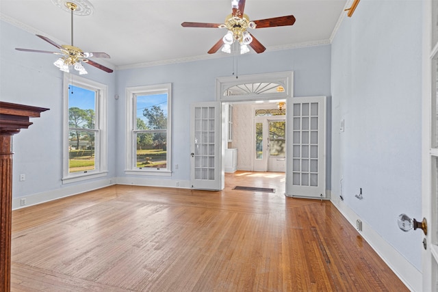 unfurnished living room featuring light hardwood / wood-style floors, ceiling fan, french doors, and ornamental molding