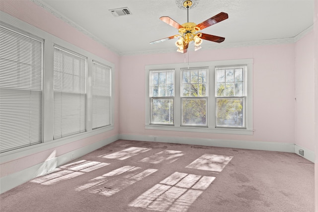 carpeted spare room featuring ceiling fan and crown molding