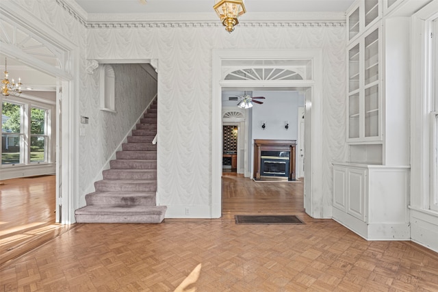 interior space with parquet flooring and ceiling fan with notable chandelier