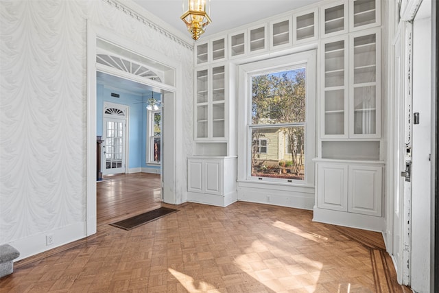 interior space featuring parquet flooring and an inviting chandelier