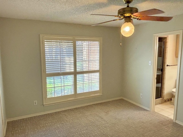 carpeted empty room featuring a textured ceiling and ceiling fan