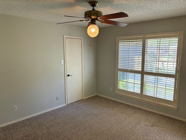 spare room featuring carpet flooring, a textured ceiling, and ceiling fan