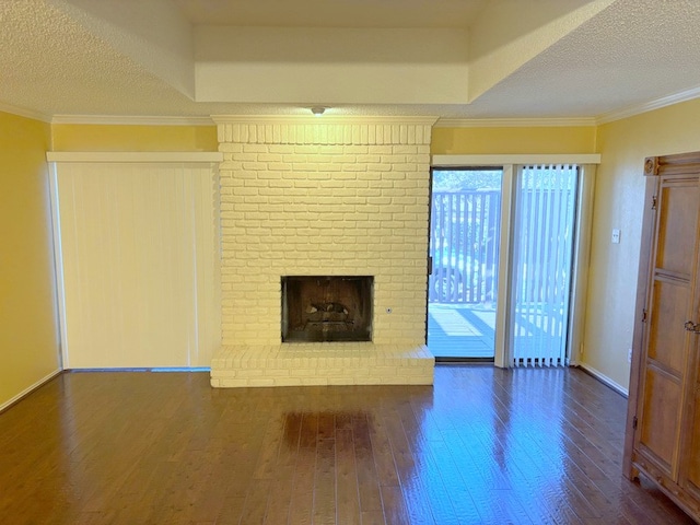 unfurnished living room with dark wood-type flooring, a fireplace, a textured ceiling, and ornamental molding