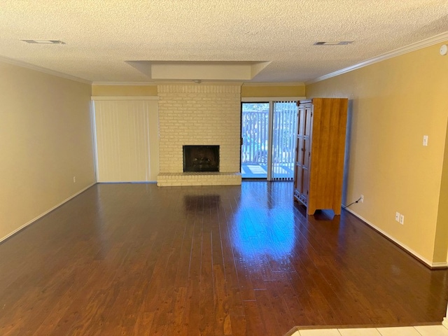 unfurnished living room featuring crown molding, hardwood / wood-style floors, a brick fireplace, and a textured ceiling