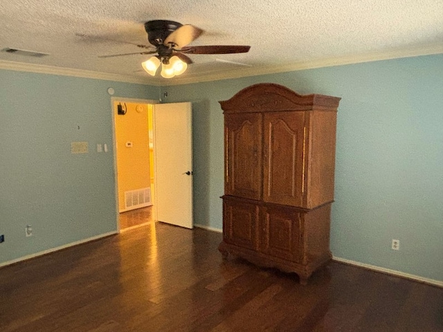 spare room with dark wood-type flooring, a textured ceiling, ceiling fan, and crown molding