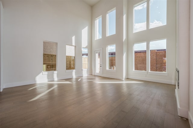 spare room featuring a high ceiling and light wood-type flooring