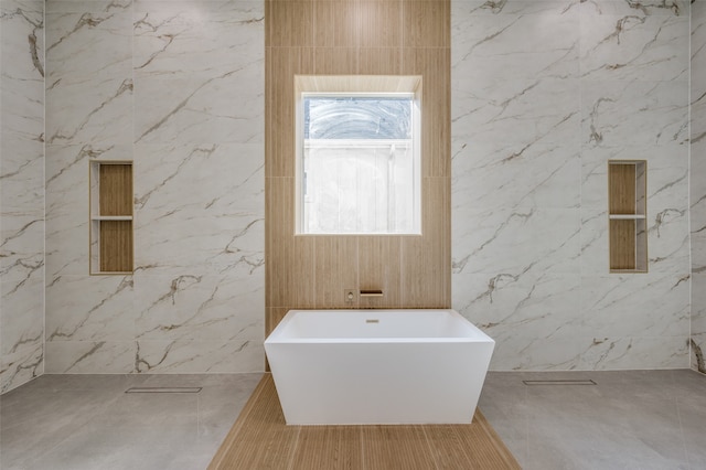 bathroom featuring a washtub and tile walls