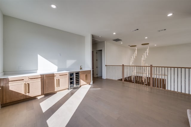 empty room featuring wine cooler and light hardwood / wood-style flooring