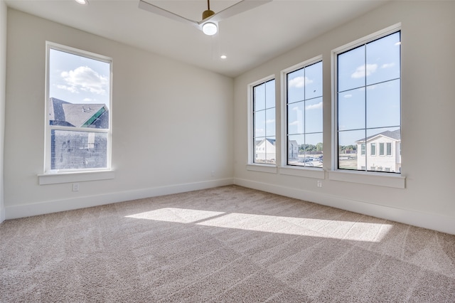 unfurnished room featuring carpet flooring, a healthy amount of sunlight, and ceiling fan