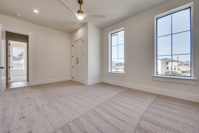 carpeted spare room with ceiling fan