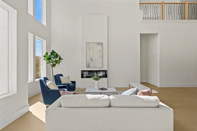 living room featuring a towering ceiling and plenty of natural light