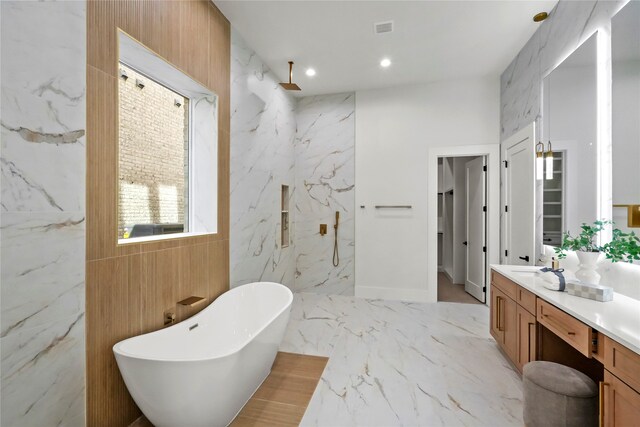 bathroom with vanity and shower with separate bathtub