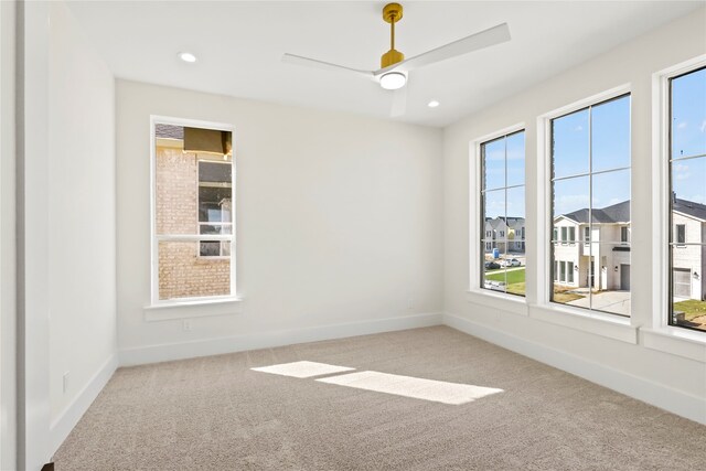 carpeted spare room featuring ceiling fan