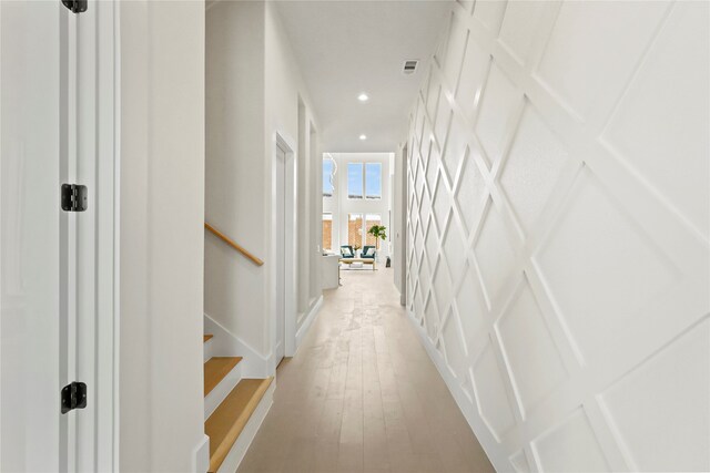 hallway with light hardwood / wood-style floors