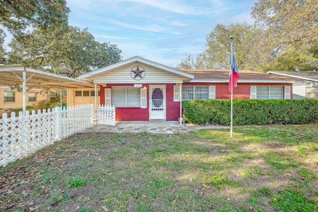 ranch-style home featuring a carport and covered porch