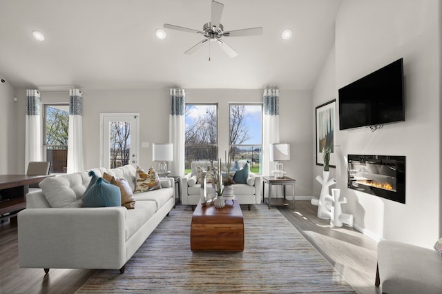 living room featuring ceiling fan, dark hardwood / wood-style floors, and plenty of natural light