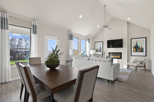 dining space featuring high vaulted ceiling, dark wood-type flooring, and ceiling fan