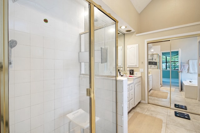 bathroom featuring walk in shower, tile patterned flooring, vanity, and lofted ceiling