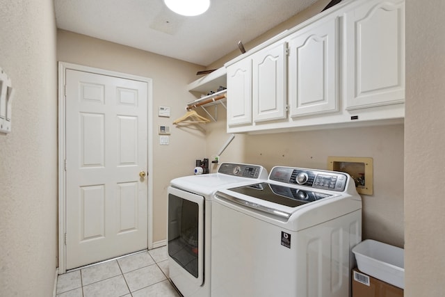 clothes washing area with separate washer and dryer, cabinets, sink, and light tile patterned flooring