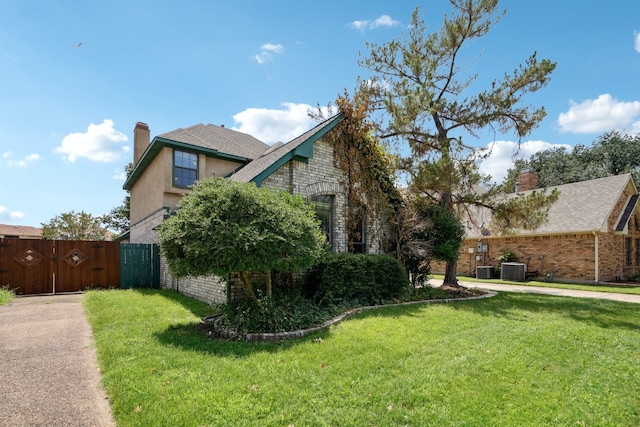 view of side of home featuring a lawn and central AC