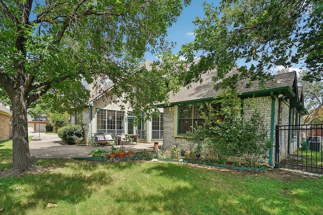 view of front of property featuring central AC unit, a patio area, and a front lawn