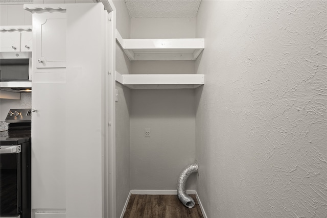 laundry room featuring dark wood-type flooring and a textured ceiling