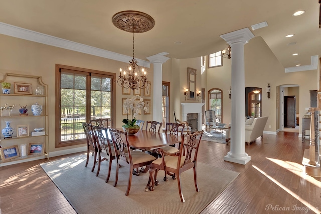 dining room with hardwood / wood-style floors, a high ceiling, an inviting chandelier, and crown molding