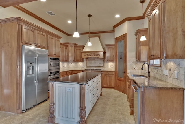 kitchen featuring stainless steel appliances, hanging light fixtures, sink, a kitchen island, and premium range hood