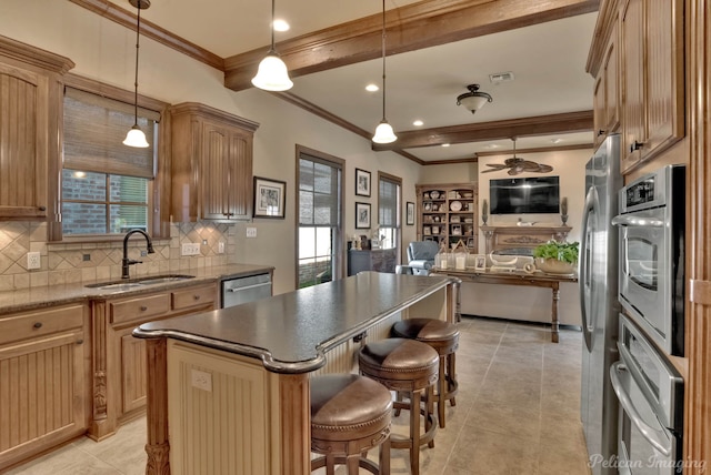 kitchen featuring stainless steel appliances, sink, decorative light fixtures, and a center island