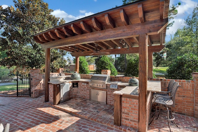 view of patio with an outdoor bar, grilling area, exterior kitchen, and ceiling fan