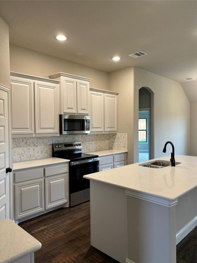 314 Mercer Dr, Josephine, TX 75173 - kitchen featuring stainless steel appliances, a sink, arched walkways, decorative backsplash, and white cabinets